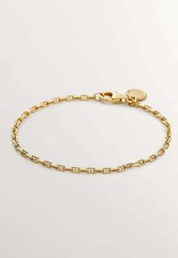 Pulsera de cadena de oro con eslabones ovalados, un cierre de langosta y un charm circular. Textura suave con un acabado pulido.