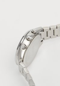 Silver stainless steel watch with a smooth round case, textured push buttons, and a polished bracelet featuring interlocking links.