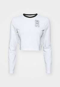 White long-sleeve crop top made of cotton with black neckline and stitching. Features a graphic logo and the year "1972" on the chest.