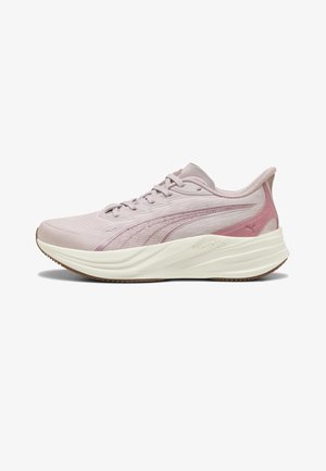 Jasnoróżowy sportowy sneaker z siateczkową cholewką, grubą białą podeszwą, sznurowaniem i logo Puma z boku, widziany od lewej strony.