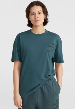 Teal katoenen T-shirt met korte mouwen, voorzien van zwarte bedrukte tekst aan de voorkant. De stof heeft een gladde textuur en een ontspannen pasvorm.