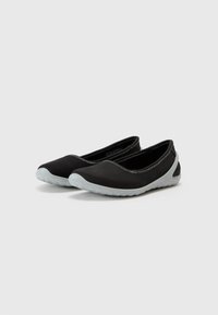 Ballerine nere con tomaia liscia, evidenziate da suole in gomma grigio chiaro a contrasto e cuciture decorative lungo i bordi.