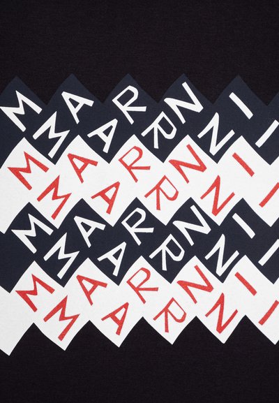 Melnā tekstila audums ar atkārtotu rakstu no zāģveida formām baltā, sarkanā un melnā krāsā. Tekstā ir maiņus novietotas burti "M", "A", "R", "N", "Z".