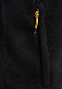 Chaqueta de forro polar negra con superficie texturizada, bolsillo vertical con cremallera y cordón amarillo para ajustabilidad.