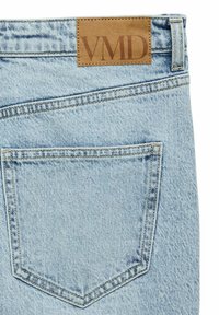 Svetlo modre kavbojke iz jeansa z ravnim pravokotnim obližem iz tan kože z vtisnjenim napisom "VMD". Vključuje zadnji žep s kontrastnim šivom.