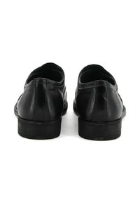 Scarpe in pelle nera con finitura liscia, punta arrotondata e tacco basso. Presentano una sottile cucitura lungo la parte posteriore e i lati.