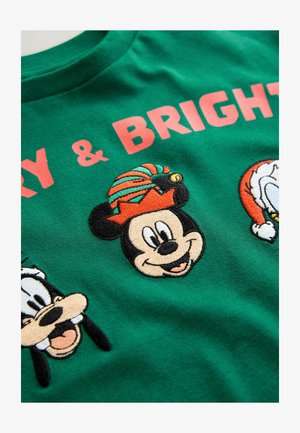 Žalias medvilninis marškinėlis su siuvinėtiais karikatūriniais personažais: Mikė Pūkuotukas vilki šventinę skrybėlę, o šalia jo pavaizduoti Goofy ir Donaldas Rūkas.