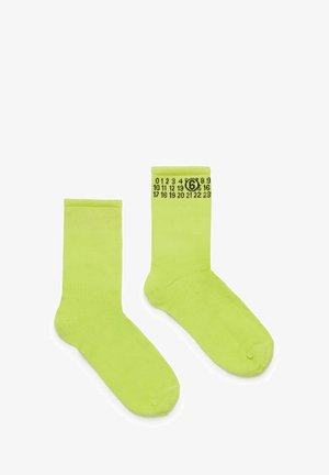 Skarpetki z bawełny w limonkowym kolorze z prążkowanymi mankietami, ozdobione czarnymi nadrukowanymi cyframi oraz wzorem okręgu na obszarze kostki.