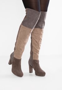 Suede stövlar över knäna med en färgblockdesign i nyanser av grått och taupe, med en sidodragkedja och en kraftig klack.