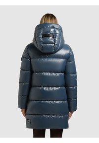 Pufferjacka i glansig marinblå med huva, med horisontella vadderade sektioner och en logotypmärke på ryggen. Slät textur.