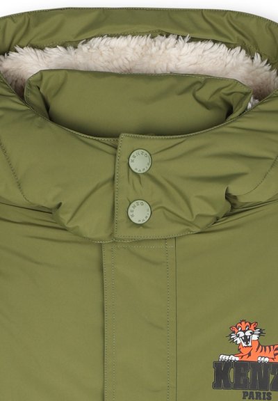 Manteau rembourré vert olive avec un col en fourrure, arborant un logo KENZO et un graphisme de tigre sur le devant, fermé par des boutons-pression.