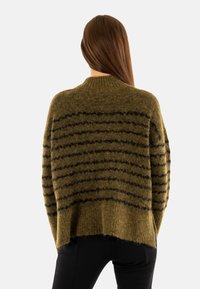 Maglione oversize a righe verdi e nere con una texture a coste, caratterizzato da un ampio scollo e una vestibilità rilassata, realizzato in morbido tessuto peloso.