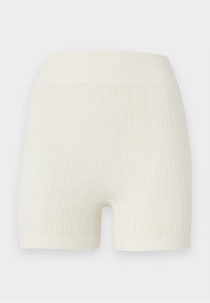 Varrás nélküli, krémszínű bordás kötött rövidnadrág széles derékrésszel és a comb közepéig érő hosszal, puha anyagból.