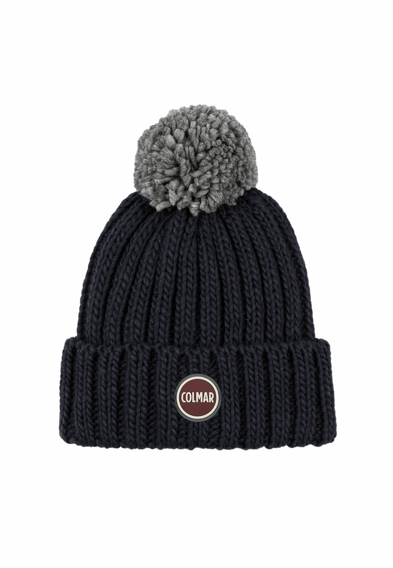 Pletene kape v temno modri barvi s sivim pom-pomom na vrhu. Ima ribasto teksturo in okroglo značko rdeče in srebrne barve na sprednji strani.