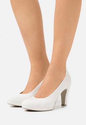 Chaussures à talons hauts blanches avec une finition en cuir lisse, bout arrondi et un talon block de hauteur moyenne. Design élégant avec des accents minimalistes.