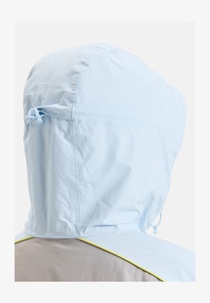 Lyseblå jakke med hette som har snøring og kontrastfargede gule detaljer i nederkant. Glatt tekstur og lett stoff.