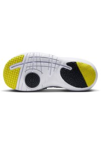 Semelle extérieure de chaussure en blanc, avec des accents jaunes et noirs. Motif de grip texturé et rainures pour la flexibilité et l'adhérence.