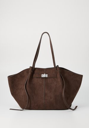 Sac fourre-tout en suède marron avec une forme large et structurée, des doubles poignées et un fermoir en métal argenté au centre. Surface texturée avec des accents minimaux.