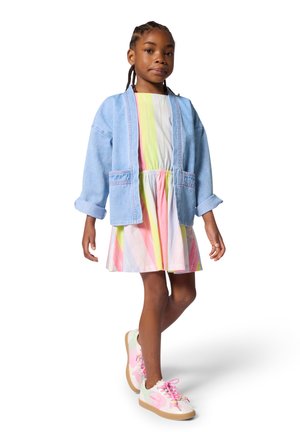 Veste en jean, bleu clair, coupe oversize avec manches retroussées ; robe rayée colorée avec des tons pastel ; baskets blanches avec des touches de rose.