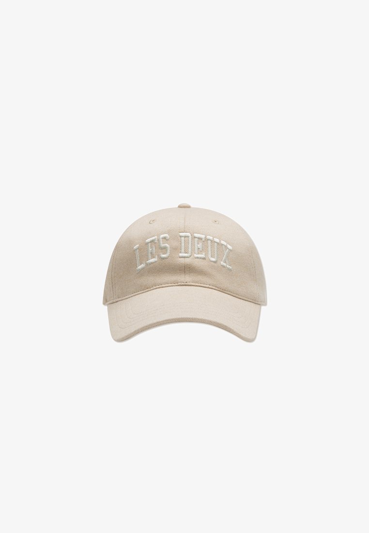 Beige bomull baseballcaps med hevet hvit brodert tekst "LES DEUX" på forsiden. Bøyd skygge og justerbar stropp bak.