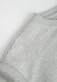 Szara bawełniana koszulka z okrągłym dekoltem i krótkimi rękawami, tkanina o fakturze z gładkim wykończeniem, z delikatnym melanżowym wzorem.