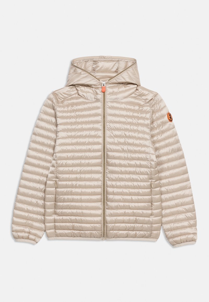 Μπεζ ελαφρύ καπιτονέ μπουφάν με κουκούλα, εμπρός φερμουάρ, πλαϊνές τσέπες, ελαστικά μανίκια και μικρό στρογγυλό πορτοκαλί λογότυπο στο μανίκι.