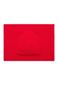 Czerwona, dziana czapka beanie na tle pasującego, płaskiego szalika. Oba elementy mają prążkowaną fakturę i są jednolite w jasnoczerwonym kolorze.
