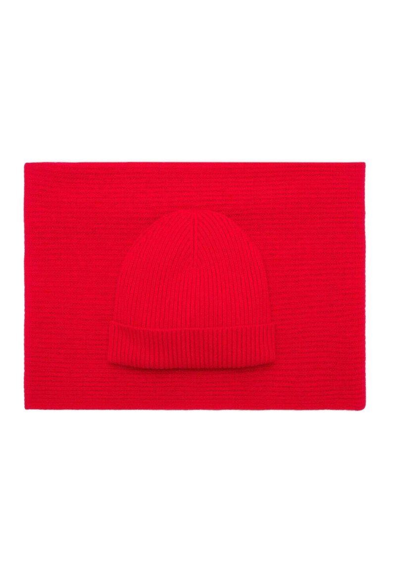Czerwona, dziana czapka beanie na tle pasującego, płaskiego szalika. Oba elementy mają prążkowaną fakturę i są jednolite w jasnoczerwonym kolorze.