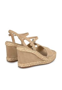 Beige Keilsandalen mit einer geflochtenen Ropesohle, Obermaterial aus Wildleder und gekreuzten Knöchelriemen. Offene Zehenpartie mit verstellbarem Schnallenverschluss.