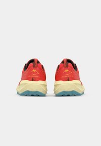 Red trail running shoes with black accents and yellow soles. Features a textured midsole and a yellow logo on the back.