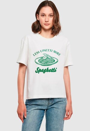 Witte t-shirt met korte mouwen met groene tekst "MINDER UPSETTI MEER Spaghetti" boven een afbeelding van spaghetti op een bord.