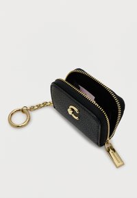 Μαύρο δερμάτινο πορτοφόλι κλειδιών με υφή, με χρυσό φερμουάρ, χρυσά αξεσουάρ και λογότυπο. Το εσωτερικό περιλαμβάνει μια υποδοχή για κάρτα και θήκη με φερμουάρ.