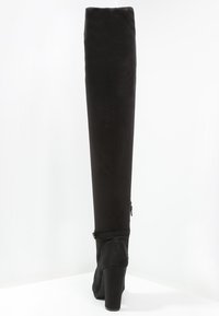 Stivali neri sopra il ginocchio realizzati in tessuto morbido, con un tacco alto chunky e una cerniera laterale per una vestibilità regolabile.