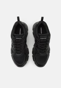 Paire de baskets épaisses noires de la marque Even&Odd, avec des détails en mesh et cuir, vues de dessus sur un fond blanc.