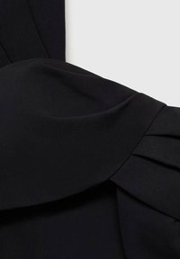Black dress section featuring a twisted fabric design with pleats, smooth texture, and structured silhouette. No visible hardware or patterns.