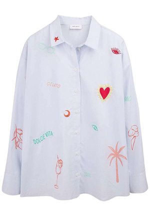 Chemise bleu clair à boutons avec des patchs brodés colorés comprenant un cœur rouge, un palmier, un cône de glace, un cocktail, et les mots "Gelato" et "Dolce Vita".