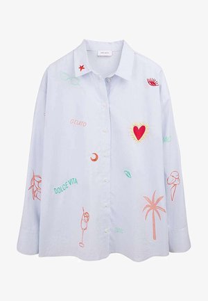 Chemise bleu clair à boutons avec des patchs brodés colorés comprenant un cœur rouge, un palmier, un cône de glace, un cocktail, et les mots "Gelato" et "Dolce Vita".