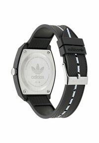 Črn gumijast pašček za uro z teksturirano površino, heksagonalna nerjaveča jeklena zadnja stran, srebrni detajli in kontrastni beli stik.