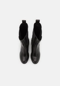 Black leather ankle boots with elastic side panels and a smooth finish. Rounded toe and pull tabs for easy wear. Flat rubber sole.