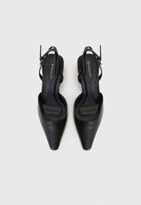 Mustat korkokengät, joissa on avonaiset kantapäät ja terävä kärki, valmistettu sileästä materiaalista. Varustettu kapeilla nilkkaremmillä ja minimalistisella muotoilulla.