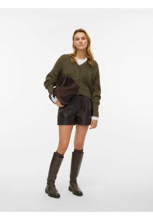 Olivově zelený pletený kardigan s knoflíky, kombinovaný s černými koženými šortkami. Outfit doplňují hnědé kozačky po kolena a tmavě hnědá kabelka.