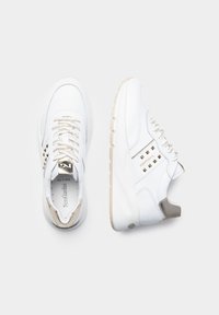 Sneaker bianche in pelle con accenti dorati, lacci texture e suole in gomma. Presentano borchie decorative sui lati e un tacco imbottito.