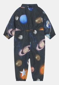 Tryckt jumpsuit i mörkt tyg med rymdtema, med planeter, stjärnor och en texturerad yta; elastiska ärmslut och midja.