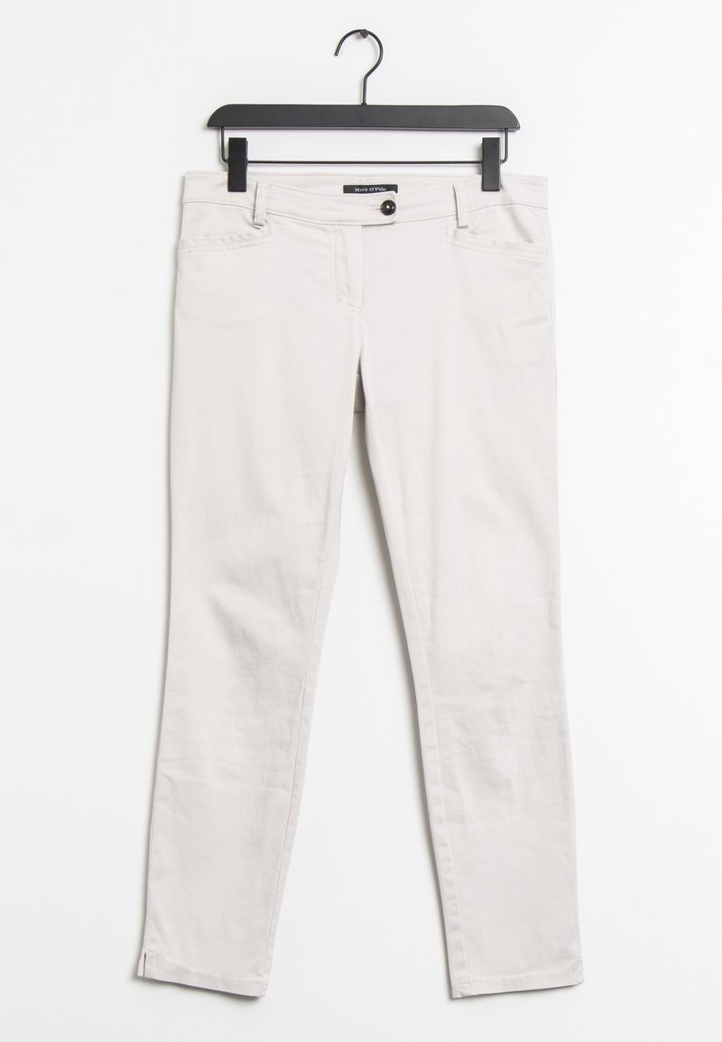 Jean en coton beige clair sur un cintre noir. Doté d'une fermeture à bouton, de cinq poches et d'une coupe slim avec des ourlets cousus.