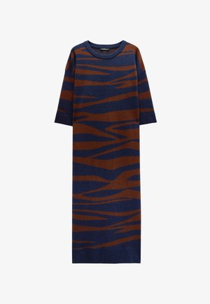 Dzianinowa, oversize sukienka-sweter z niebieską bazą i brązowymi abstrakcyjnymi paskami. Okrągły dekolt i krótkie rękawy. Miękka faktura i proste cięcie.