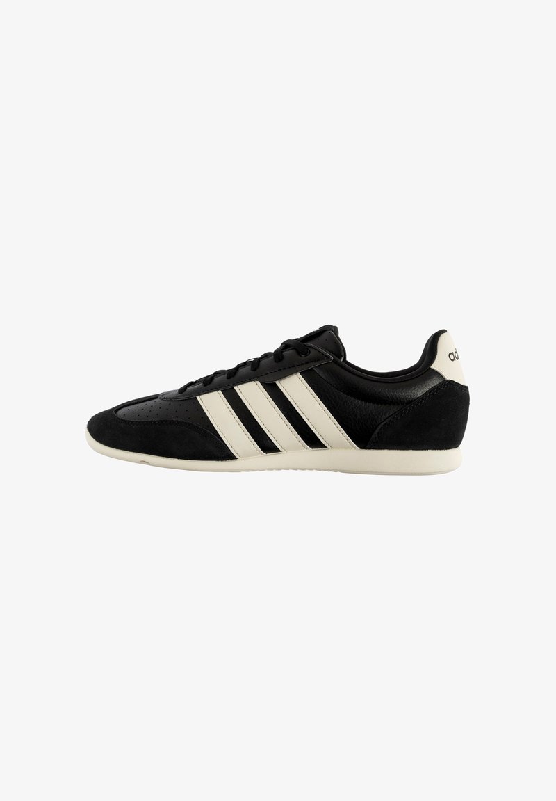Baskets en cuir noir et daim avec trois bandes blanches et semelle blanche, design low-top et lacets.