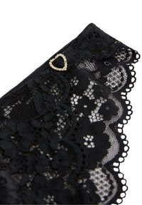 Sort blonderstof med blomsterdesignet mønster og bølgede kanter, fremhævet af en guldfarvet hjerteformet pynt. Blød og delikat tekstur.