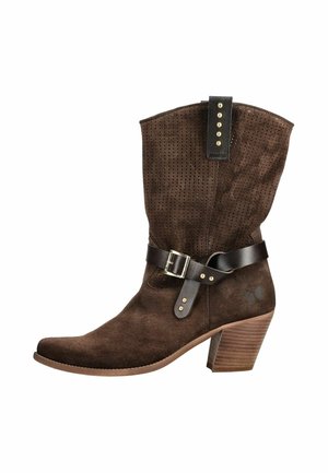 Botte mi-mollet en daim brun avec empeigne perforée, sangle en cuir foncé avec boucle, clous dorés et talon en bois empilé.