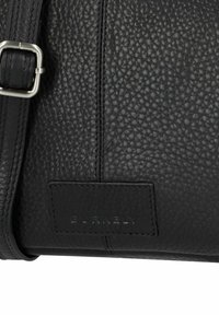 Borsa a tracolla nera in pelle con superficie texturizzata, accessori in argento, tracolla regolabile e etichetta del marchio impressa sul lato.