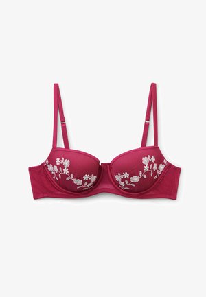 Rød bøjle-bh med justerbare stropper og hvidt blomsterbroderi på skålene, lagt fladt på en hvid baggrund.